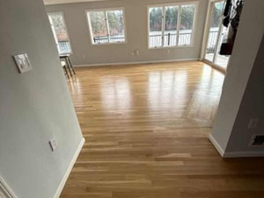Precision Flooring Renovation showcasing a newly installed hardwood floor in a bright, open living space.